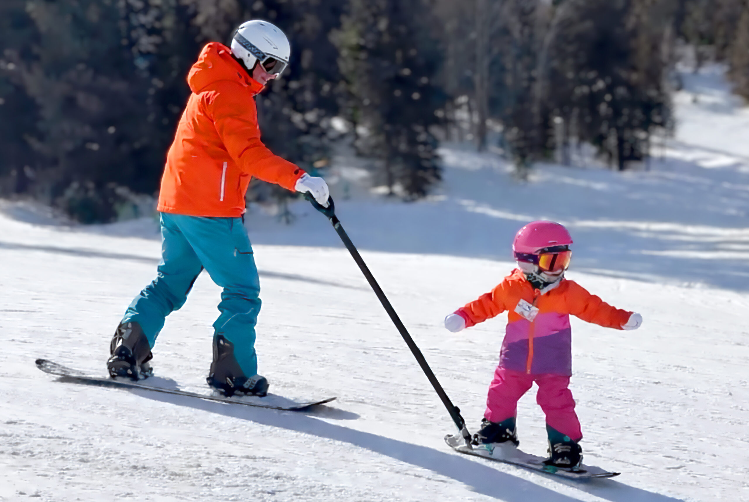 Hero: on-snow lifestyle — parent and child riding together